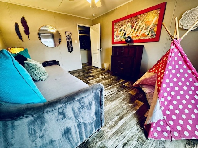 bedroom with a ceiling fan, wood finished floors, and crown molding