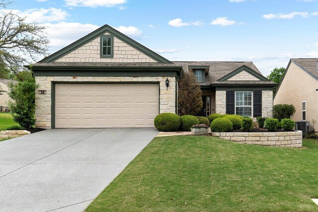108 Silver Bonnet Dr, Georgetown, TX 78633 - view of front of house with stone siding, driveway, a front yard, and an attached garage