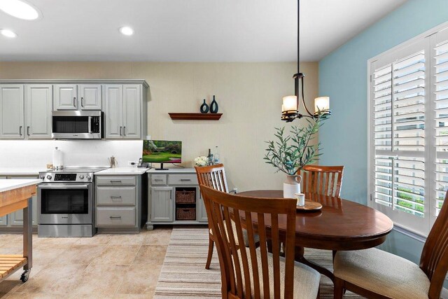 108 Silver Bonnet Dr, Georgetown, TX 78633 - kitchen with stainless steel appliances, gray cabinets, light countertops, a chandelier, and recessed lighting