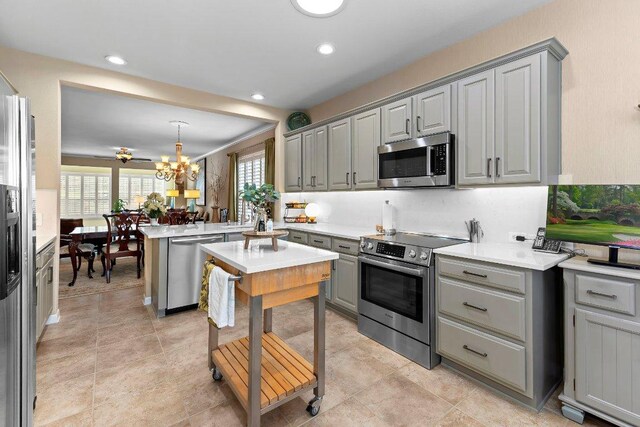 108 Silver Bonnet Dr, Georgetown, TX 78633 - kitchen with appliances with stainless steel finishes, gray cabinets, a peninsula, a chandelier, and recessed lighting