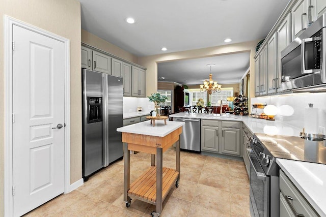 108 Silver Bonnet Dr, Georgetown, TX 78633 - kitchen with stainless steel appliances, gray cabinets, a chandelier, light countertops, and recessed lighting