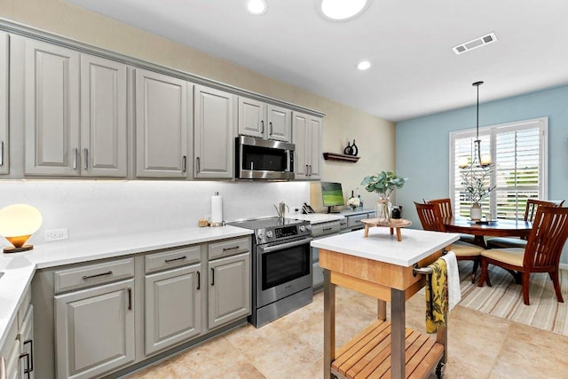 108 Silver Bonnet Dr, Georgetown, TX 78633 - kitchen featuring appliances with stainless steel finishes, gray cabinets, decorative light fixtures, light countertops, and recessed lighting