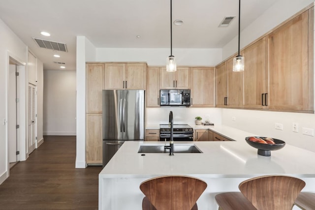 507 Sabine St Unit 601, Austin, TX 78701 - kitchen with stainless steel appliances, light brown cabinets, a peninsula, light countertops, and a kitchen breakfast bar