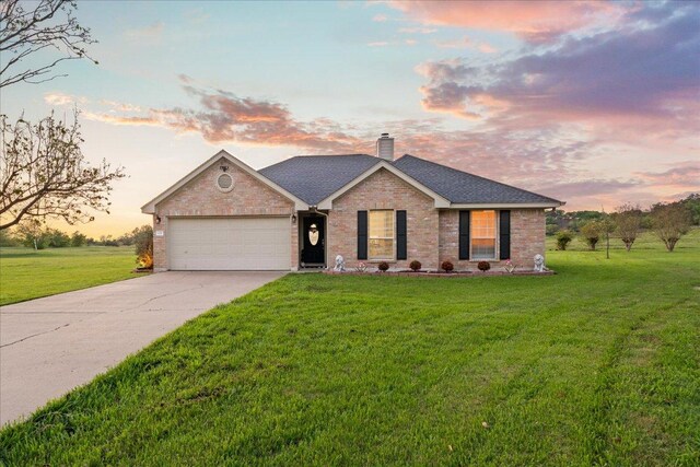 125 Fairway Ct, Bastrop, TX 78602 - ranch-style home with a garage, a chimney, brick siding, concrete driveway, and a front lawn