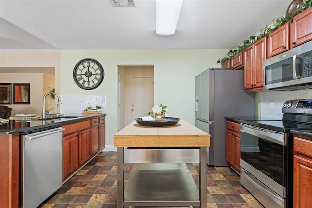 125 Fairway Ct, Bastrop, TX 78602 - kitchen featuring appliances with stainless steel finishes, decorative backsplash, dark stone finish flooring, and dark countertops