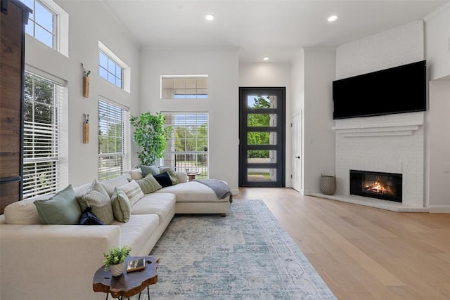 611 Ladin Ln, Lakeway, TX 78734 - living room featuring wood finished floors, recessed lighting, a brick fireplace, and a towering ceiling