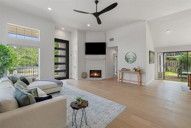 611 Ladin Ln, Lakeway, TX 78734 - living area with a high ceiling, a ceiling fan, a fireplace, light wood-style floors, and recessed lighting