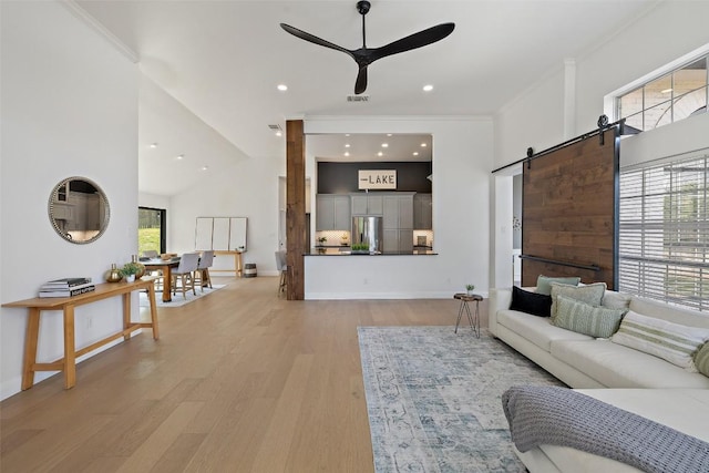 611 Ladin Ln, Lakeway, TX 78734 - living area featuring ceiling fan, a barn door, light wood finished floors, a high ceiling, and crown molding