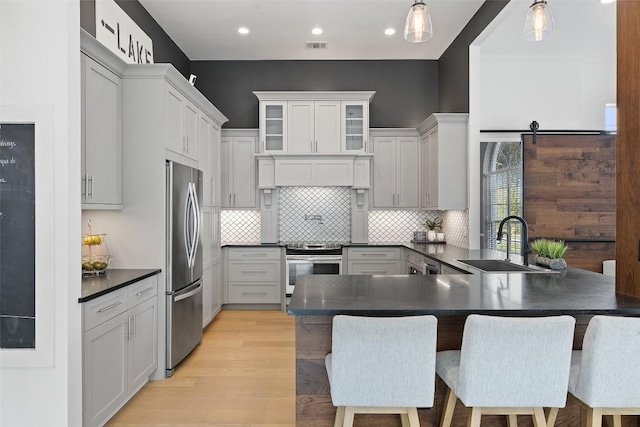 611 Ladin Ln, Lakeway, TX 78734 - kitchen with appliances with stainless steel finishes, dark countertops, a peninsula, a breakfast bar, and backsplash