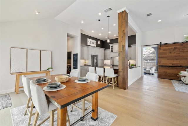 611 Ladin Ln, Lakeway, TX 78734 - dining room featuring light wood-type flooring, a towering ceiling, and recessed lighting
