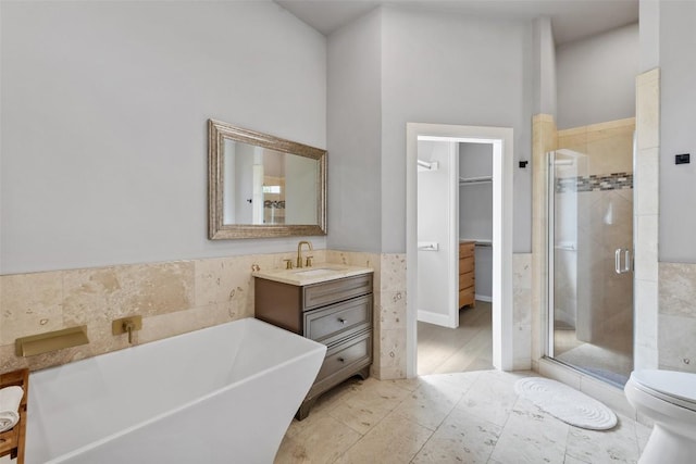 611 Ladin Ln, Lakeway, TX 78734 - full bath with tile walls, a shower stall, a soaking tub, vanity, and a walk in closet