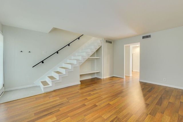 7409 Shadow Hill Dr Unit 105, Austin, TX 78731 - unfurnished living room with stairway, wood finished floors, and baseboards
