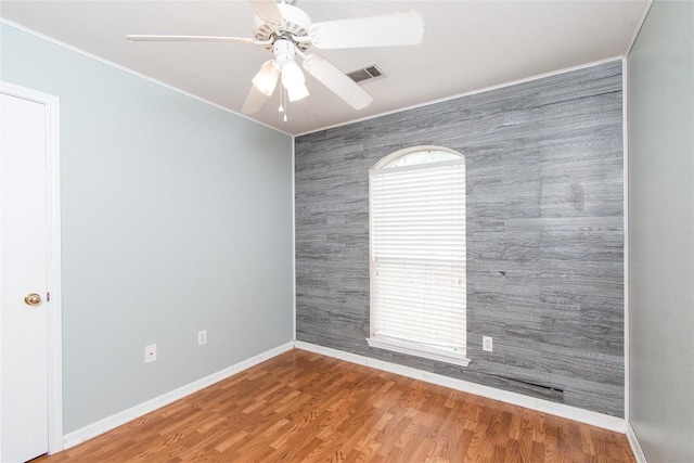 7201 Pappus Ct, Temple, TX 76502 - empty room featuring crown molding, an accent wall, ceiling fan, and wood finished floors