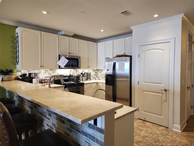 1001 The Cape Rd Unit 32, Horseshoe Bay, TX 78657 - kitchen with appliances with stainless steel finishes, a peninsula, light countertops, tasteful backsplash, and a breakfast bar area