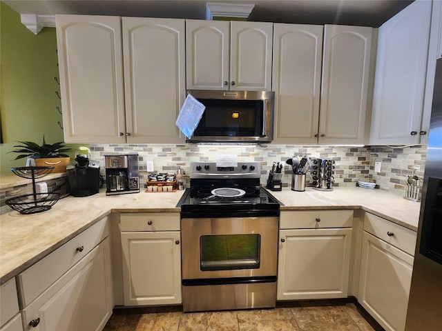 1001 The Cape Rd Unit 32, Horseshoe Bay, TX 78657 - kitchen featuring appliances with stainless steel finishes, tasteful backsplash, white cabinets, and light stone finish floors