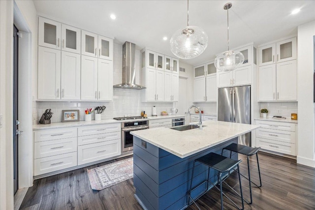 1303 Harriet Ct Unit A, Austin, TX 78756 - kitchen featuring appliances with stainless steel finishes, wall chimney range hood, a sink, backsplash, and white cabinetry
