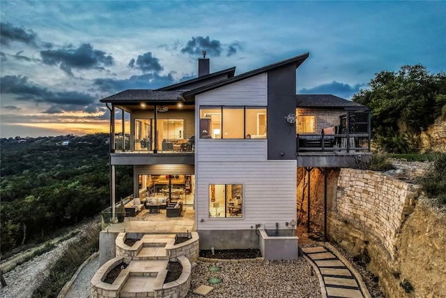 8612 Tip Top Dr Unit 2, Jonestown, TX 78645 - back of property at dusk with a patio area, a chimney, a balcony, a sunroom, and an outdoor hangout area