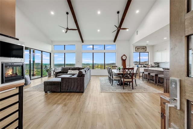 8612 Tip Top Dr Unit 2, Jonestown, TX 78645 - living area featuring high vaulted ceiling, beam ceiling, light wood-style floors, a glass covered fireplace, and a ceiling fan