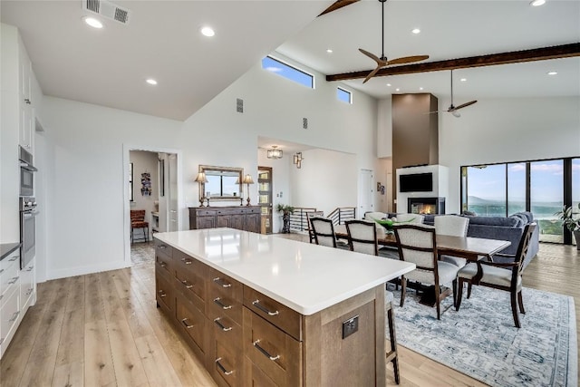 8612 Tip Top Dr Unit 2, Jonestown, TX 78645 - kitchen with a ceiling fan, high vaulted ceiling, a center island, plenty of natural light, and white cabinetry