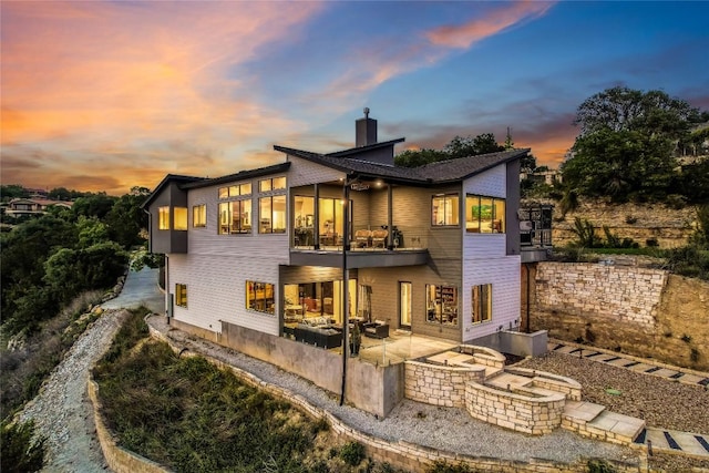 8612 Tip Top Dr Unit 2, Jonestown, TX 78645 - back of house at dusk featuring a patio area, an outdoor fire pit, and a chimney