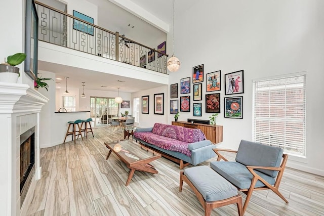 12203 Arrowwood Dr, Austin, TX 78727 - living area featuring a fireplace, baseboards, light wood finished floors, and a towering ceiling