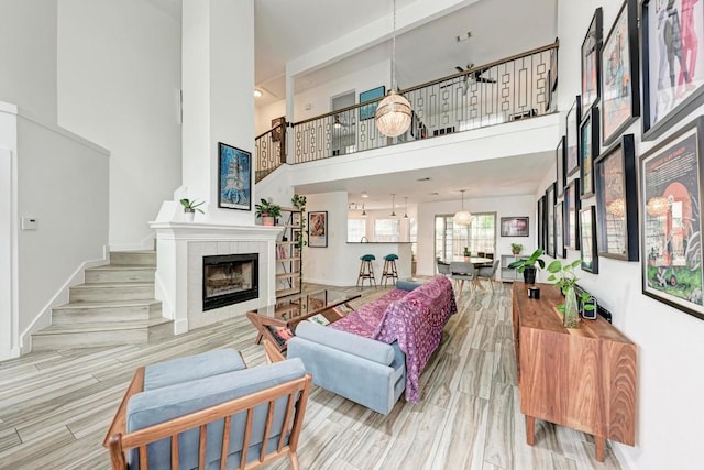 12203 Arrowwood Dr, Austin, TX 78727 - living area featuring a high ceiling, a tile fireplace, stairs, and wood finished floors