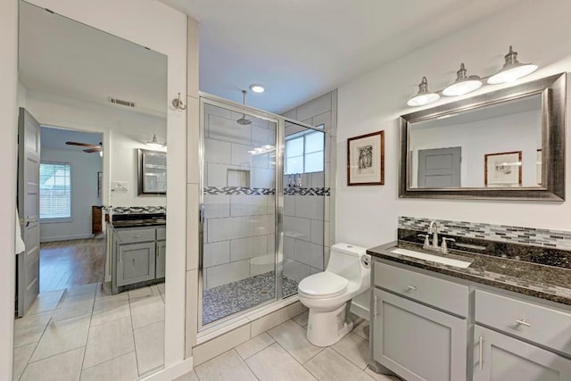 12203 Arrowwood Dr, Austin, TX 78727 - full bath with a shower stall, two vanities, tile patterned floors, a ceiling fan, and baseboards