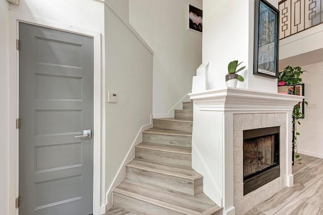 12203 Arrowwood Dr, Austin, TX 78727 - stairway with wood finished floors, a tile fireplace, and baseboards