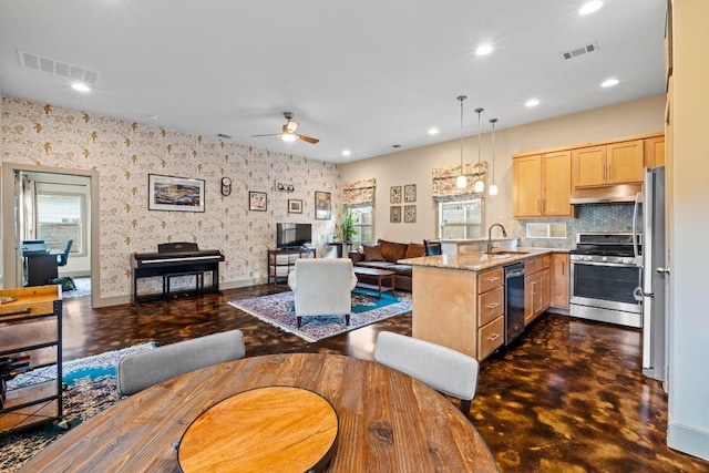 1907 E 20th St, Austin, TX 78722 - kitchen featuring appliances with stainless steel finishes, light brown cabinetry, under cabinet range hood, a peninsula, and ceiling fan