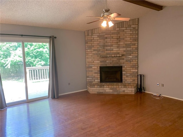 2304 Lasso Dr, Round Rock, TX 78681 - unfurnished living room featuring wood finished floors, ceiling fan, a brick fireplace, and a textured ceiling
