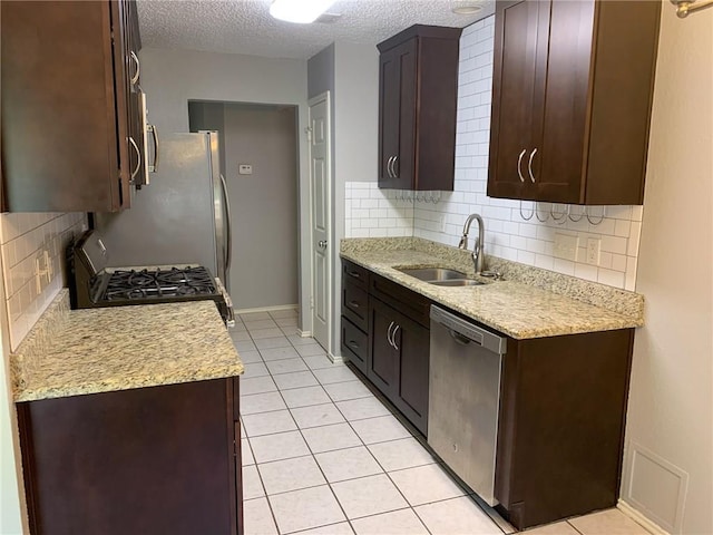 2304 Lasso Dr, Round Rock, TX 78681 - kitchen featuring stainless steel appliances, a textured ceiling, tasteful backsplash, dark brown cabinets, and light tile patterned flooring
