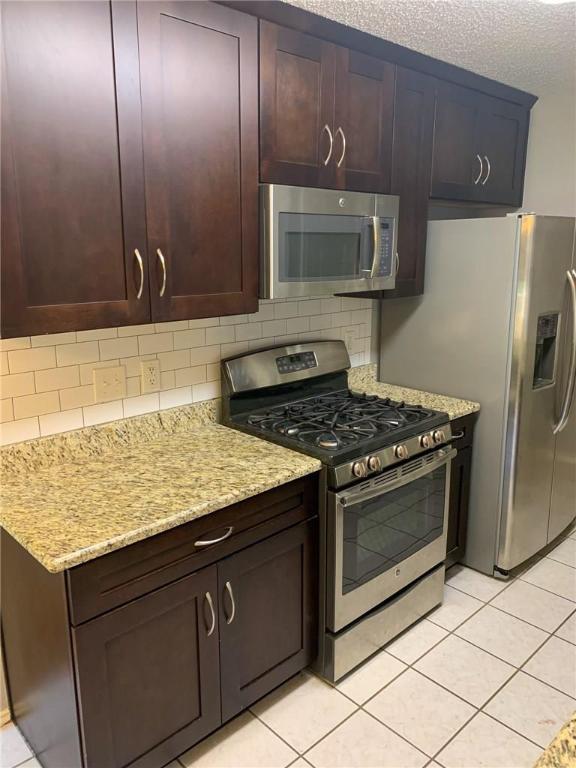 2304 Lasso Dr, Round Rock, TX 78681 - kitchen featuring stainless steel appliances, light tile patterned floors, and backsplash