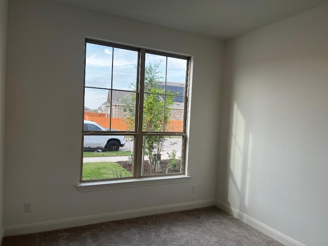 unfurnished room with baseboards and carpet