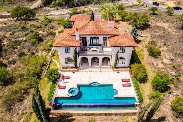1300 Apache Tears, Horseshoe Bay, TX 78657 - back of house with a balcony, a chimney, a patio, a tile roof, and stucco siding