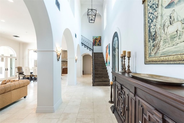 1300 Apache Tears, Horseshoe Bay, TX 78657 - entrance foyer with arched walkways, light tile patterned floors, stairs, and a towering ceiling