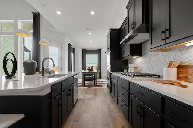 20502 Ed Townes Ter, Manor, TX 78653 - kitchen with a sink, backsplash, light countertops, dark cabinets, and recessed lighting