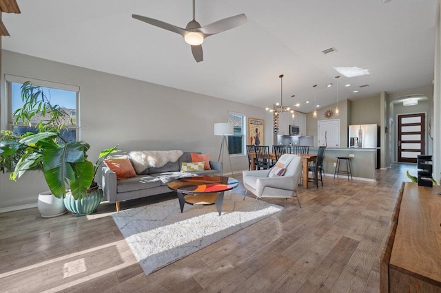 17500 Bridgefarmer Blvd, Pflugerville, TX 78660 - living room with vaulted ceiling, light wood-type flooring, ceiling fan, and a chandelier