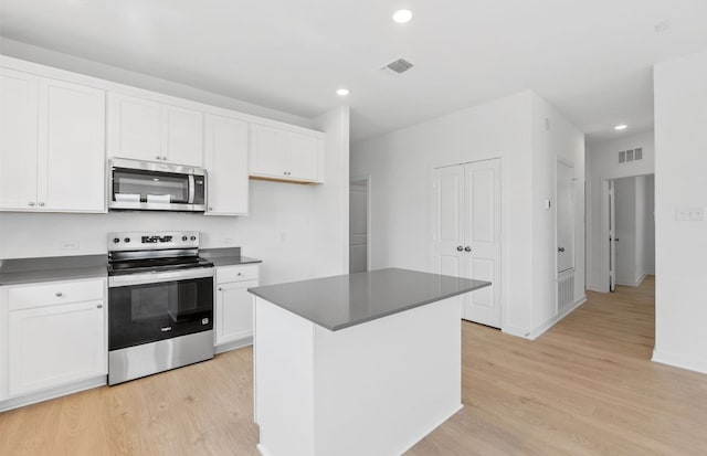 918 Childress Dr, Temple, TX 76501 - kitchen featuring appliances with stainless steel finishes, light wood finished floors, dark countertops, recessed lighting, and white cabinetry