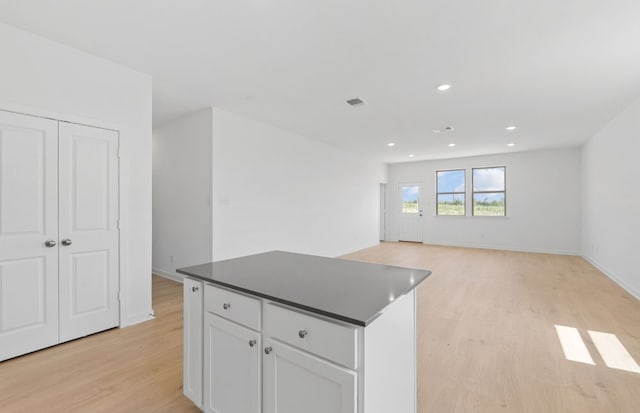 918 Childress Dr, Temple, TX 76501 - kitchen with light wood finished floors, a center island, dark countertops, white cabinetry, and recessed lighting