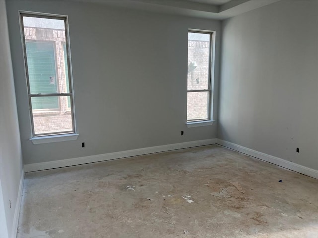 empty room featuring baseboards and concrete flooring