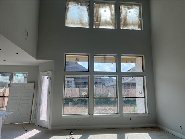 entryway featuring baseboards and a towering ceiling