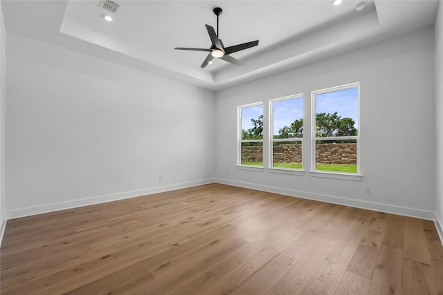 5513 Olimpico Way, Leander, TX 78641 - empty room featuring a tray ceiling, light wood-type flooring, ceiling fan, and recessed lighting