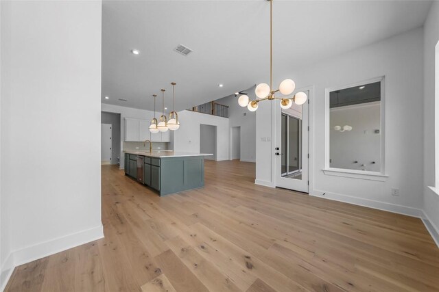 5513 Olimpico Way, Leander, TX 78641 - kitchen featuring a chandelier, light wood-style flooring, light countertops, a kitchen island with sink, and pendant lighting