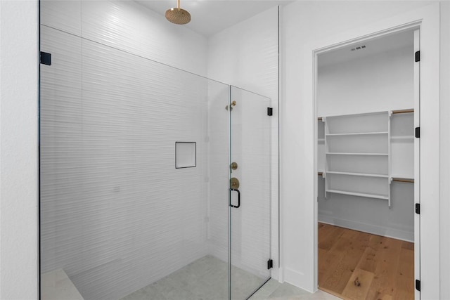 5513 Olimpico Way, Leander, TX 78641 - bathroom with a stall shower, wood finished floors, and a spacious closet