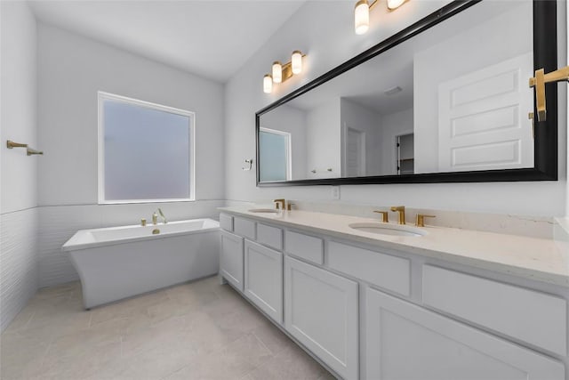 5513 Olimpico Way, Leander, TX 78641 - bathroom with double vanity, a freestanding bath, tile patterned flooring, and a wainscoted wall