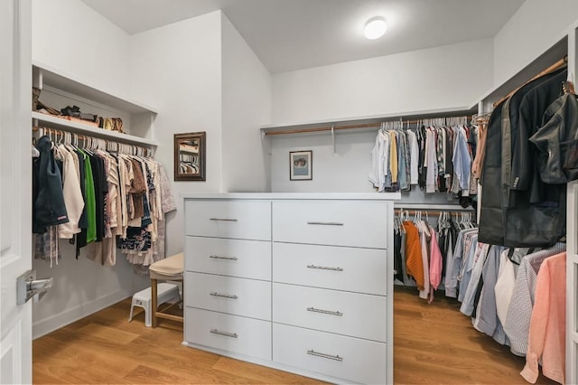 walk in closet with light wood-style flooring