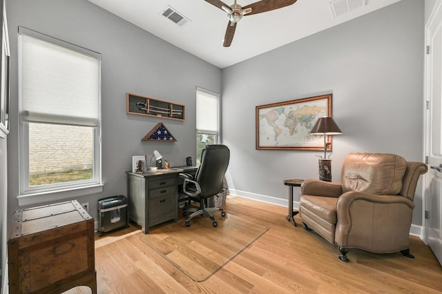 office featuring light wood finished floors, visible vents, baseboards, and ceiling fan