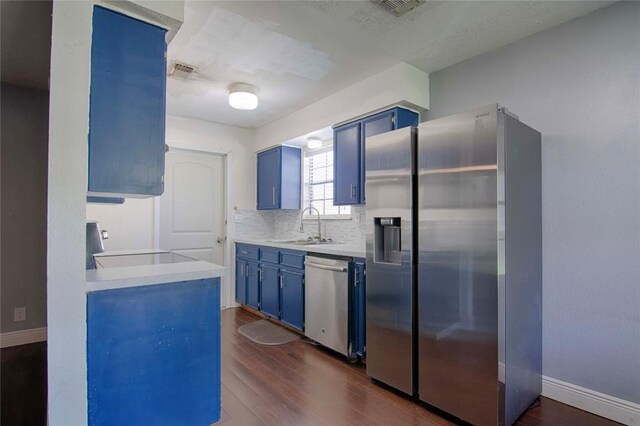 311 August St, Schulenburg, TX 78956 - kitchen with dark wood-style flooring, baseboards, light countertops, stainless steel appliances, and blue cabinets