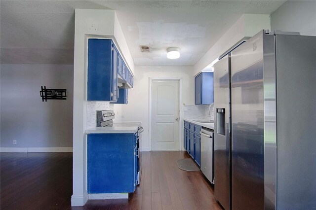311 August St, Schulenburg, TX 78956 - kitchen with stainless steel appliances, dark wood-style flooring, visible vents, and blue cabinets