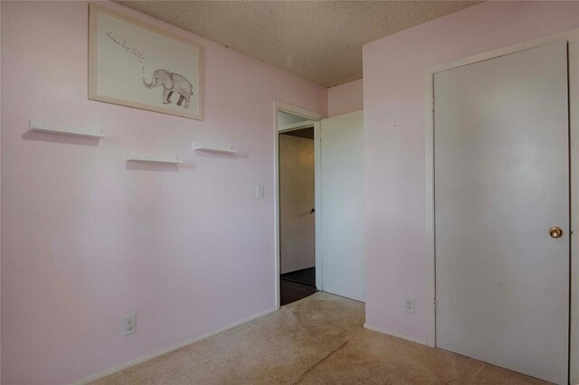 311 August St, Schulenburg, TX 78956 - unfurnished bedroom featuring a textured ceiling and carpet